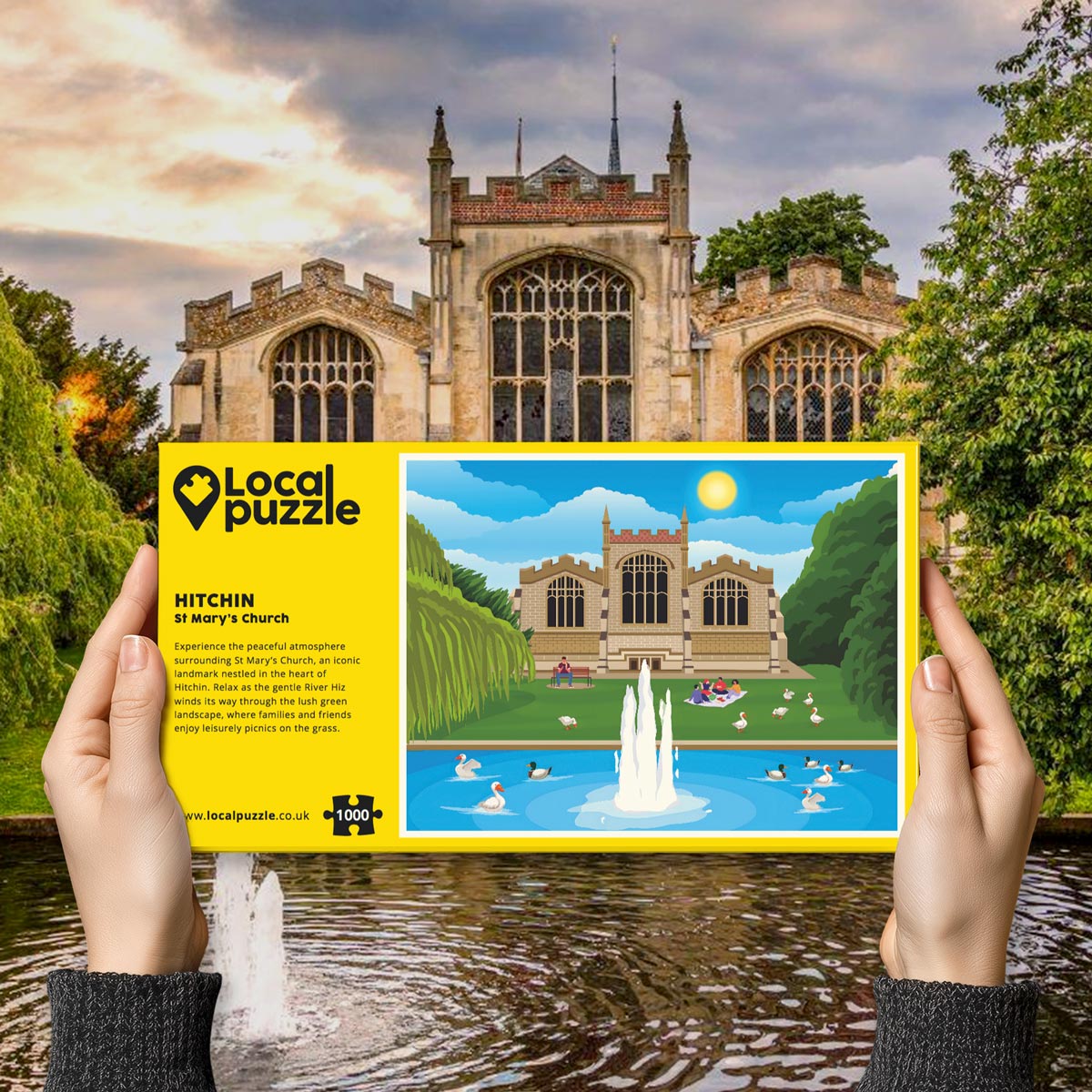 Person holding "local Puzzle" box for Hitchin St Mary's Church jigsaw puzzle in front of the actual location