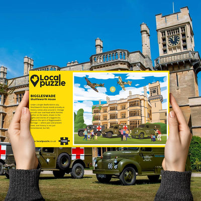 Hands holding "local Puzzle" box for Biggleswade Shuttleworth House jigsaw puzzle in front of the actual location 