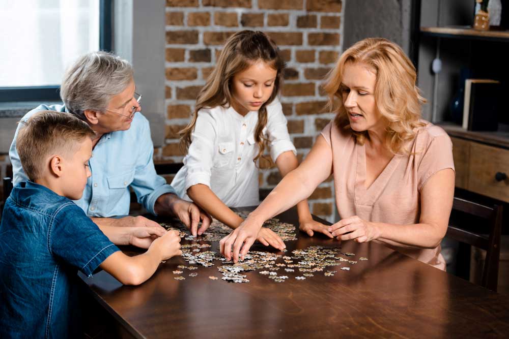 Grandparents and grandchildren playing with jigsaw puzzle for adults