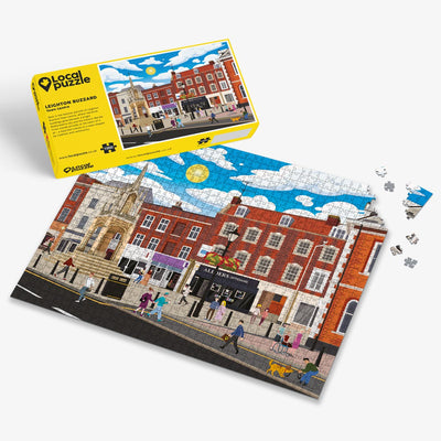 Leighton Buzzard Town Centre Jigsaw puzzle with a colourful scene of a town centre and yellow box packaging on a white background