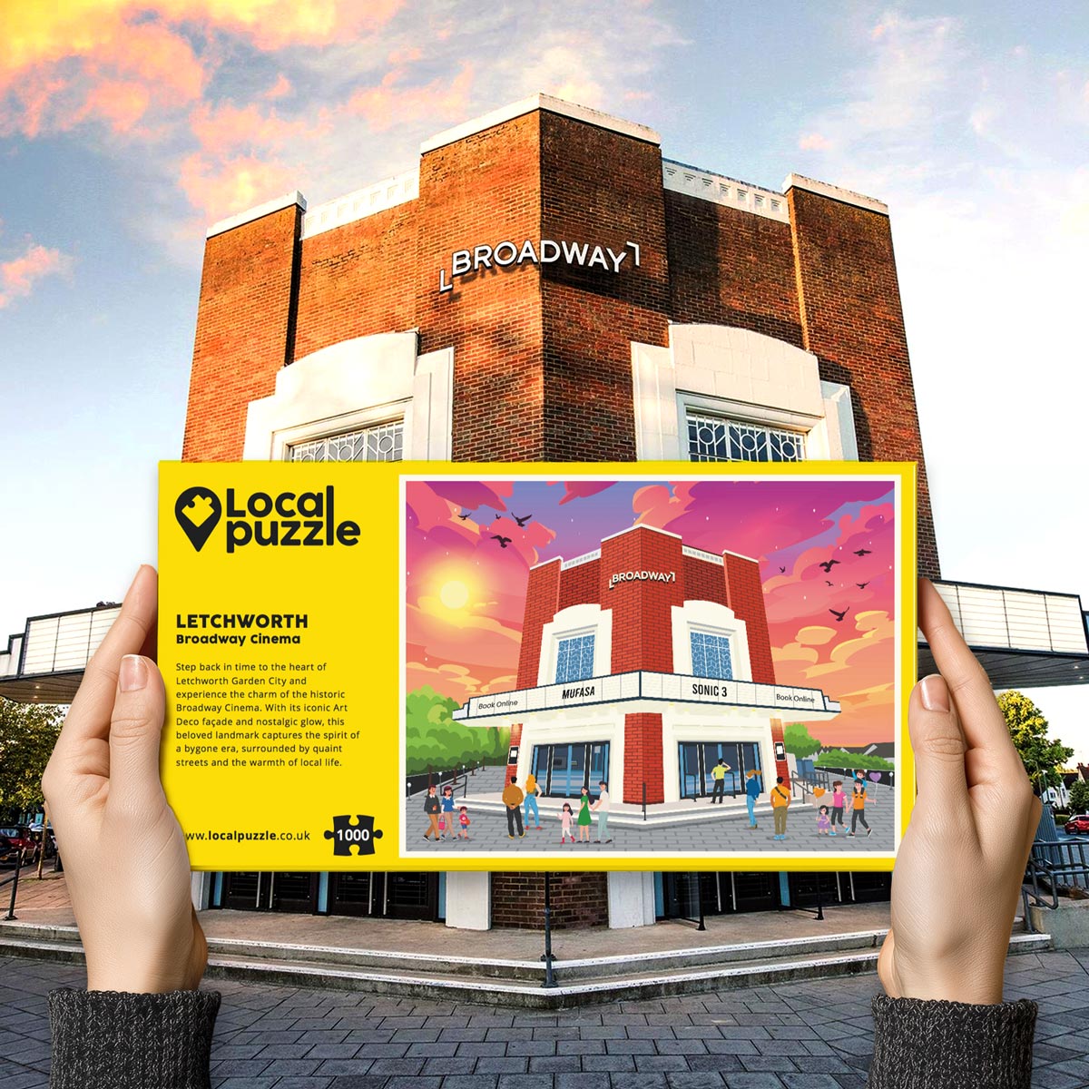 Person holding "local Puzzle" box for Letchworth Broadway Cinema jigsaw puzzle in front of the actual location 