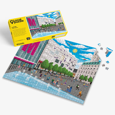 Luton town centre Jigsaw puzzle with a colourful scene of a town centre and yellow box packaging on a white background