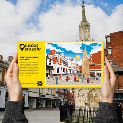 Person holding "local Puzzle" box for Waltham Cross Town Centre jigsaw puzzle in front of the actual location 