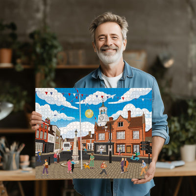 Man holding a completed Ampthill Town Centre jigsaw puzzle in his office or studio
