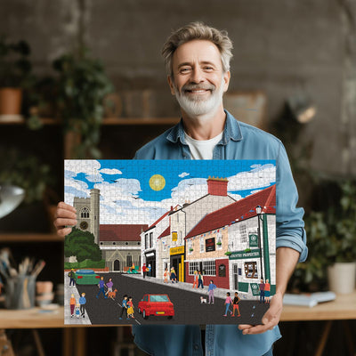 Man holding a completed Welwyn High Street jigsaw puzzle in his office or studio