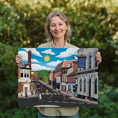 Woman holding a completed Harpenden High Street jigsaw puzzle in her garden