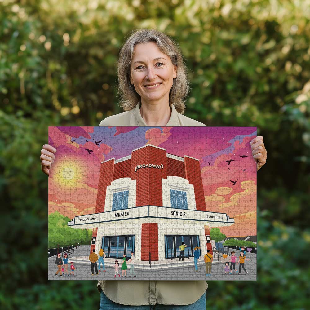 Woman holding a completed Letchworth Broadway Cinema jigsaw puzzle in her garden