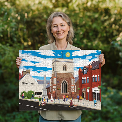 Woman holding a completed Shefford High Street jigsaw puzzle in her garden