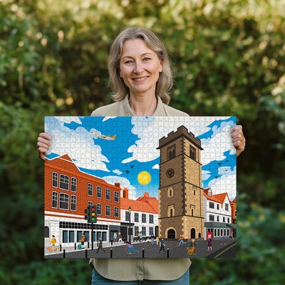 Woman holding a completed St Albans Clock Tower jigsaw puzzle in her garden